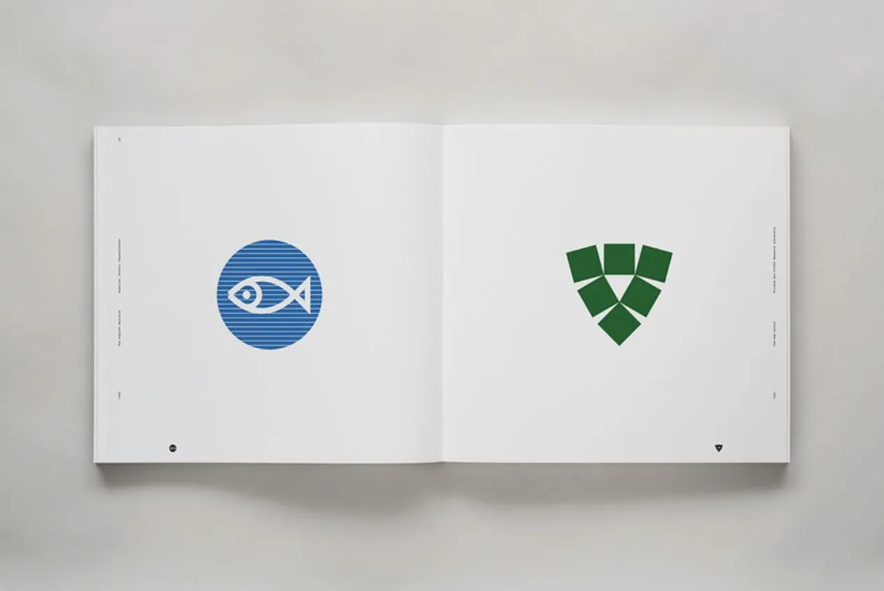 An open book displaying two minimalist logos on a white background. The left page shows a blue circle with a stylized white fish, and the right page has a green shield composed of several geometric shapes.