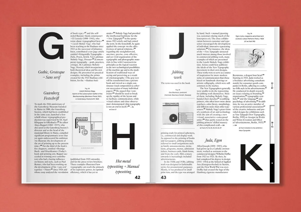 An open book on a red surface, featuring two pages of text with large, bold letters "G," "H," "I," "J," and "K" in the margins. The book entries discuss typography, including historical and technical details, with small images and diagrams accompanying th
