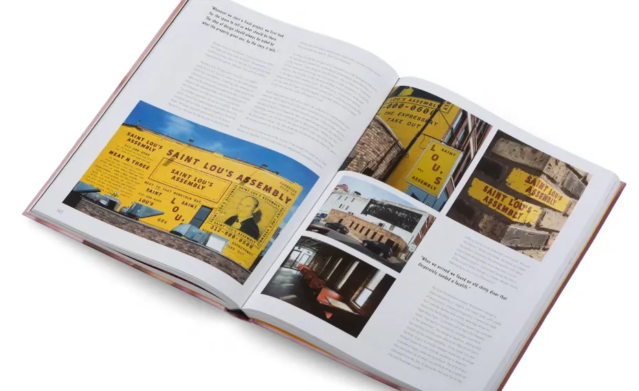 An open book displaying a spread with text and color photographs. The left page includes two yellow signs from the Saint Louis Assembly, while the right page features more photos, including scenic views and architectural images. Both pages have paragraphs